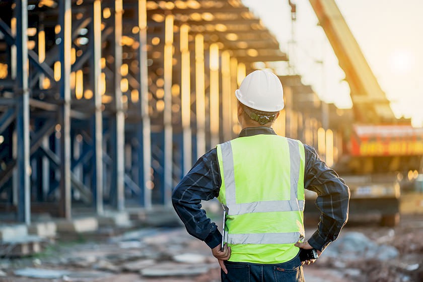 Ausschreibungen für Generalunternehmer: Generalübernehmer steht vor der Baustelle und prüft den Fortschritt