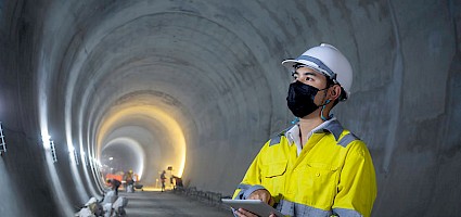 Arbeitssicherheit im Tiefbau: Arbeiter mit Schutzkleidung bei Tunnelarbeiten.