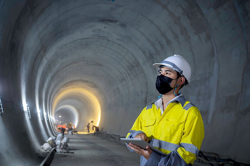 Arbeitssicherheit im Tiefbau: Arbeiter mit Schutzkleidung bei Tunnelarbeiten.