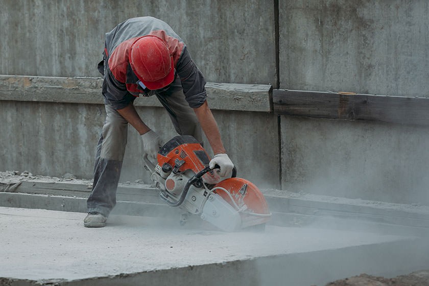 Ausschreibungen Betonsägearbeiten: Arbeiter schneidet Betonboden mit Betonsäge