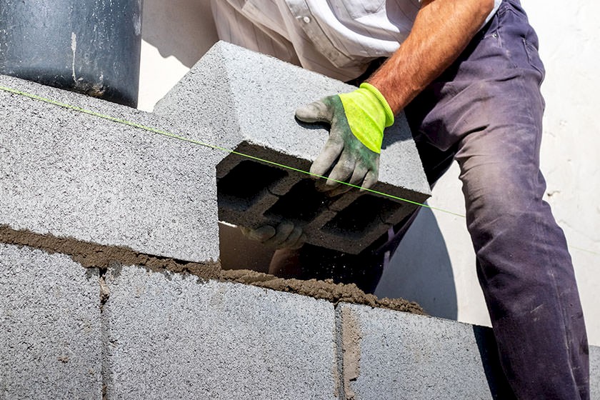 Ausschreibungen Porenbetonarbeiten: Bauarbeiter platziert Porenbetonziegel